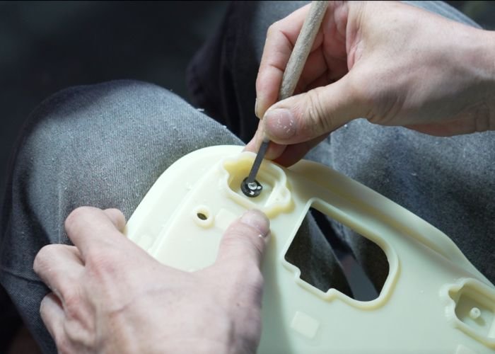 Hand finishing edges and corners on plastic prototype parts.