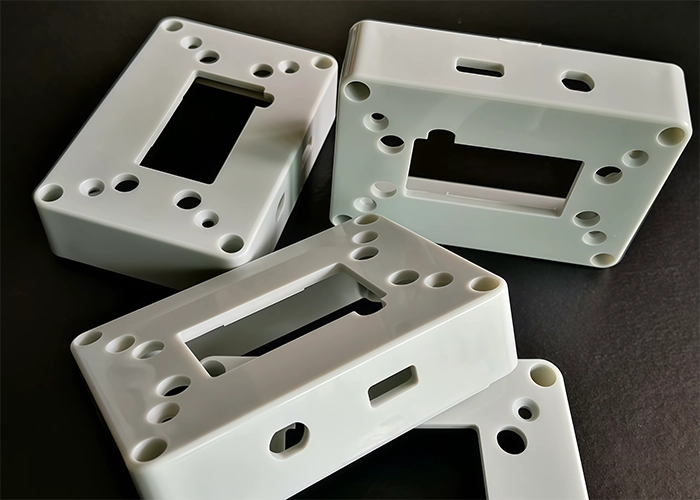 White CNC machined ABS plastic housings with holes and openings for prototype assembly