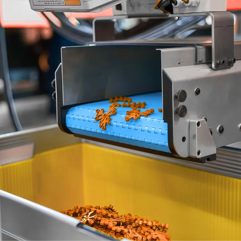 Plastic processing machine producing orange plastic, partial close-up of production line, real shot of plastic extrusion manufacturing process